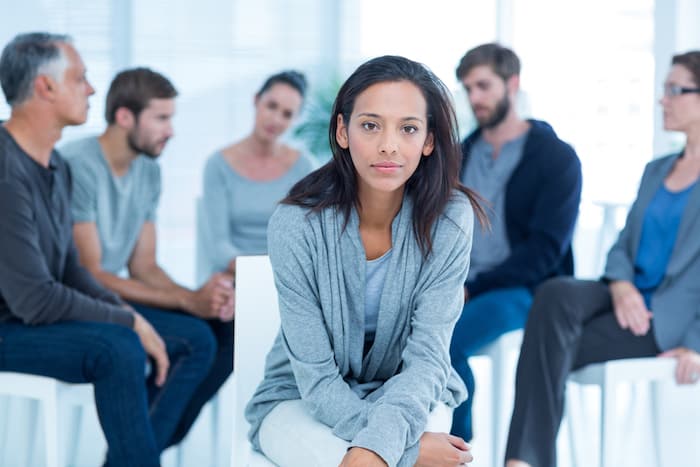 Woman comforting another in rehab group at a therapy session