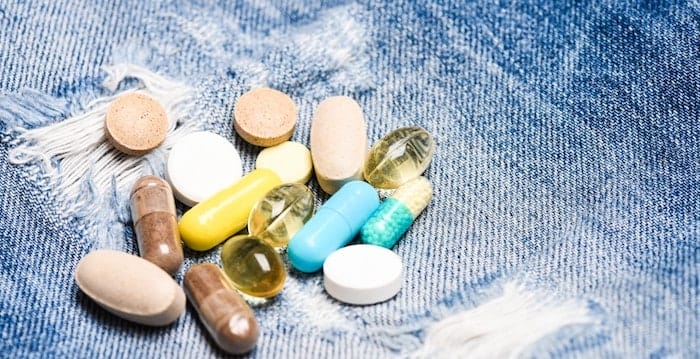 Medicine prescription. Health care and illness. Dose and addiction. Drug addiction. Medicine and treatment concept. Drugs on denim background. Set of colorful pills. Mixing medicines. Fast treatment.