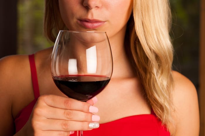 Beautiful woman drinks red wine outdoor on a hot summer afternoon