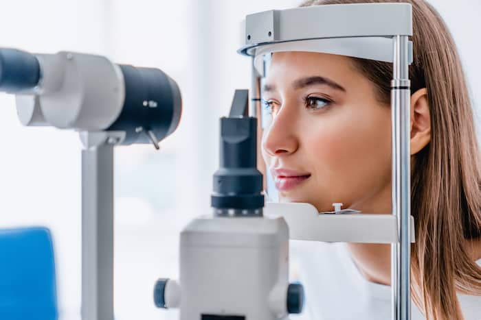 Beautiful young girl checking the eye vision in modern ophthalmology clinic