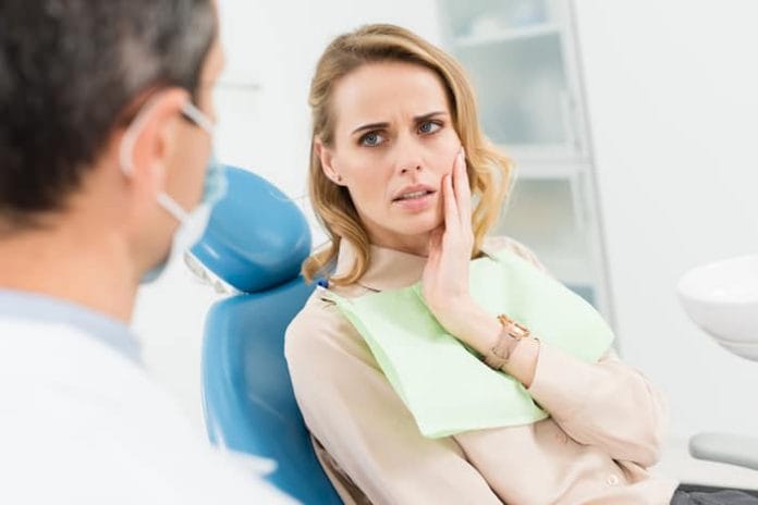 Female patient concerned about toothache in modern dental clinic