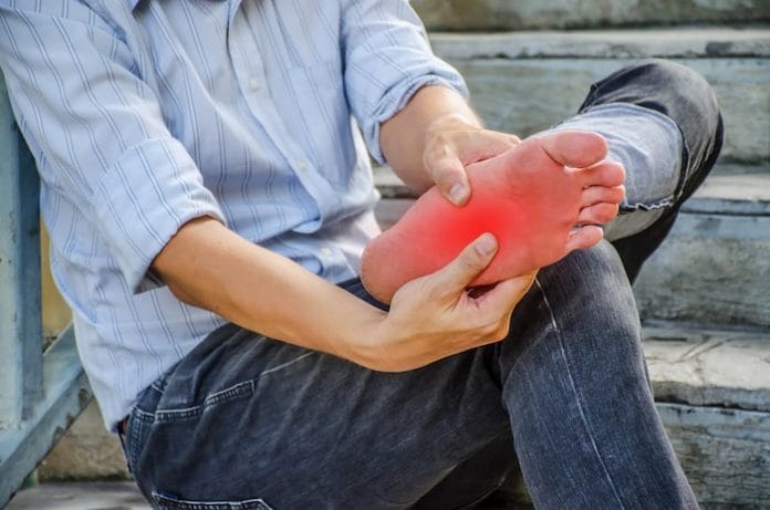close-up young man feeling pain in his foot because leg cramps and ankles on stair, Have ankle pain, Health concept