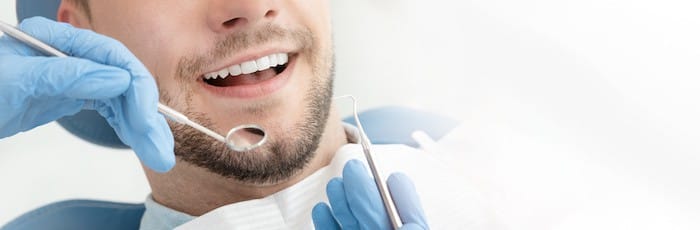 Young man at the dentist. Dental care, taking care of teeth. Picture with copy space for background.