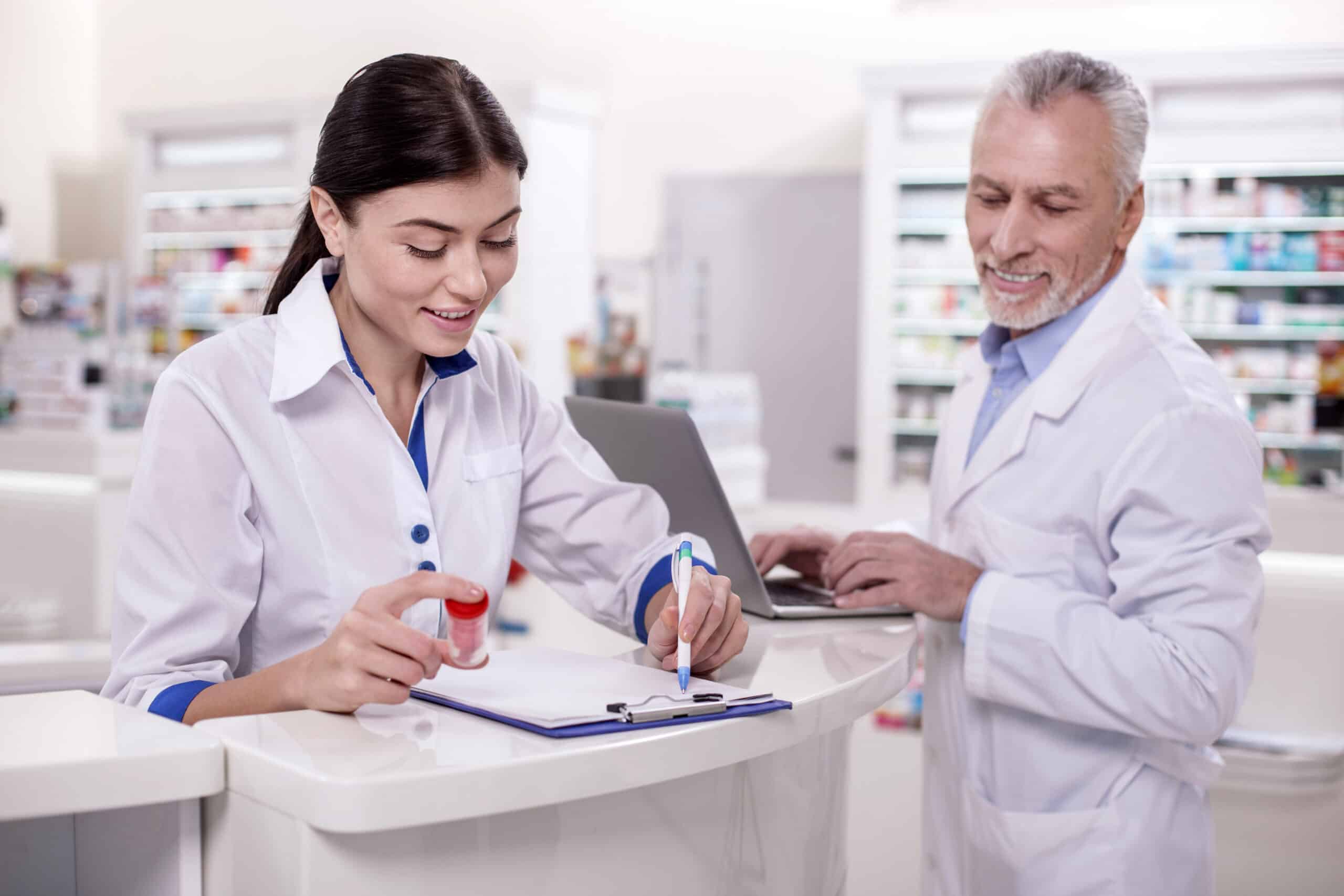 No experience. Positive female pharmacist taking notes while mature male doctor using laptop
