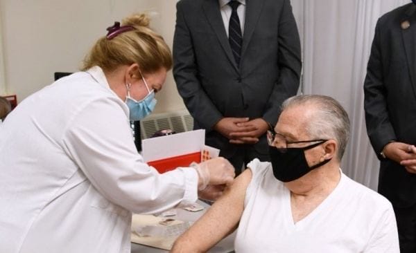 A man getting vaccinated by a nurse