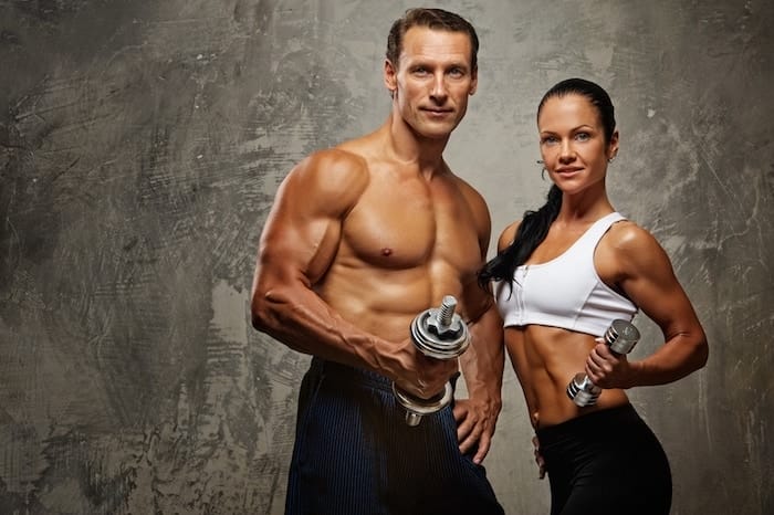 Athletic man and woman with dumbells.