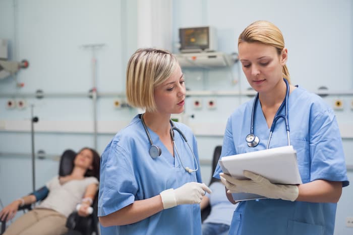 Nurses looking at a clipboard in hospital ward