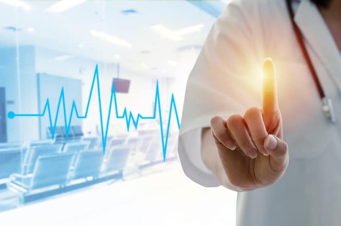 female doctor with stethoscope hand pointing touching virtual screen interface with his finger and heartbeat line on waiting room in hospital background, medical innovation technology concept
