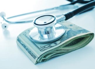 a stethoscope on a wad of US dollar bills, depicting the concepts of the health care industry or the health care costs