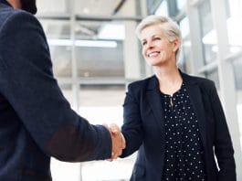 Cropped shot of two businesspeople shaking hands while standing in a modern office