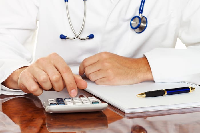 doctor with a calculator. calculation of costs and revenues in physician practice and hospital