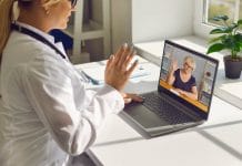 Telemedicine and e-health services. Closeup of doctor waving hand at computer screen greeting senior woman at online consultation. General practitioner using laptop to video call mature patient