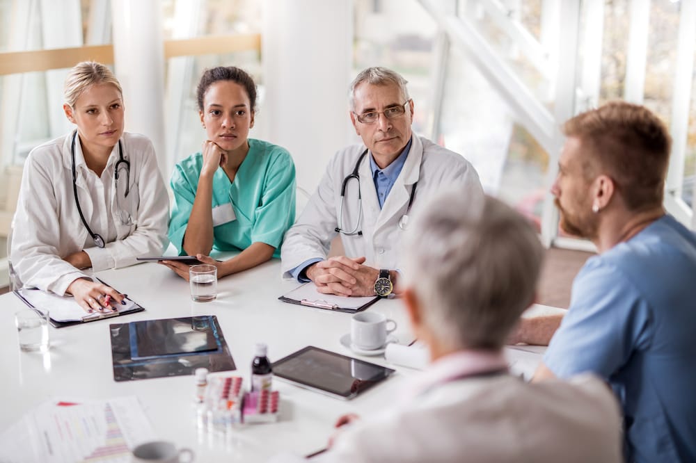 Group of healthcare workers attending a meeting in the hospital.