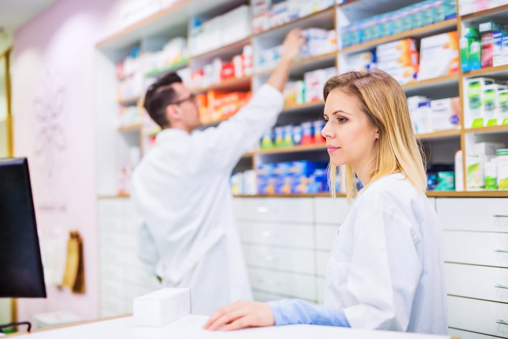 Two friendly pharmacists working in a drugstore.