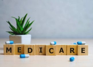 MEDICARE word made with building blocks, medical concept background.