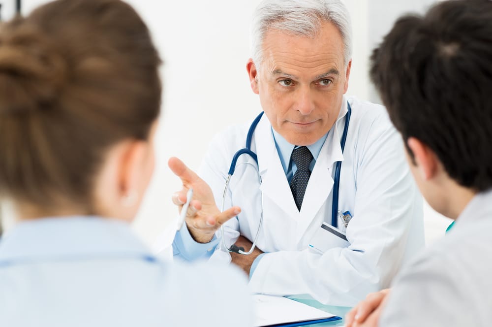 Mature Doctor Involved In Serious Discussion With His Patients