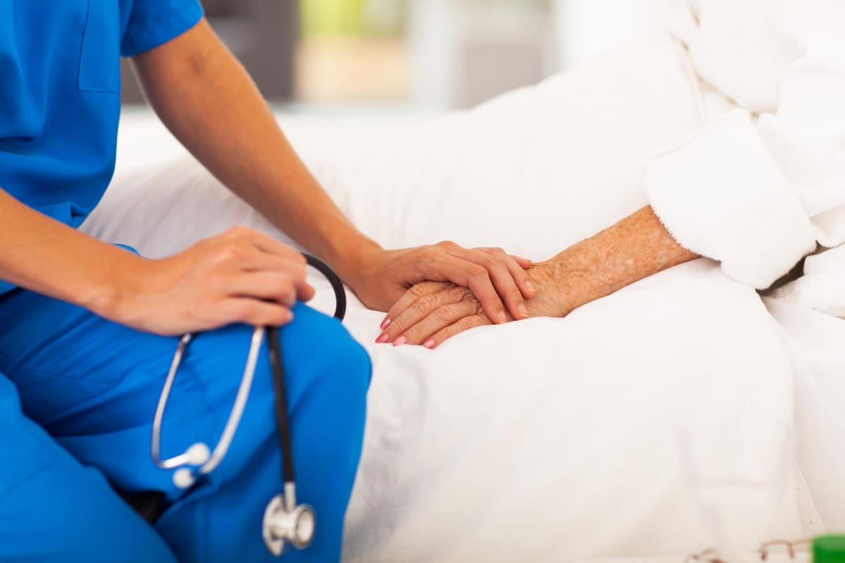 Nurse holding a patient's hand.