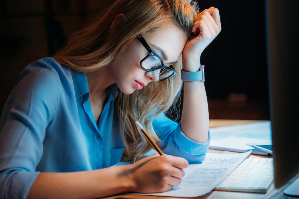 A photo of a young woman or night owl working late for an article asking are night owls unhealthy.