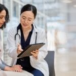 Doctor, woman patient and tablet for consulting with results, medical info and talk for healthcare with mockup space. Japanese medic, digital touchscreen or show video for surgery, wellness or advice