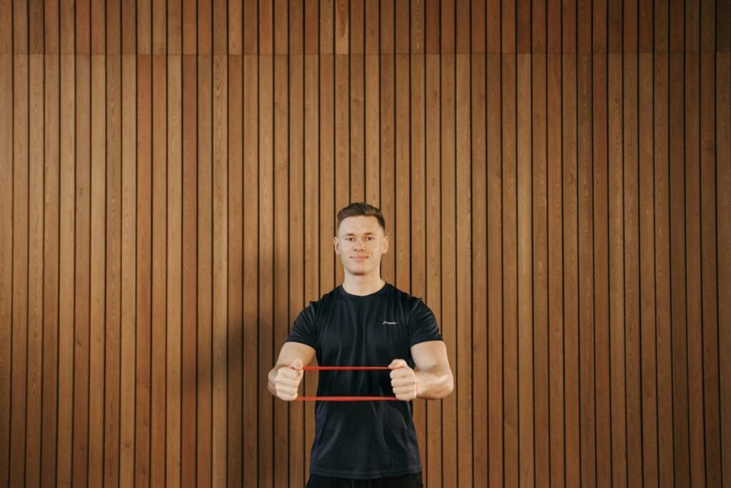 The Benefits of Testosterone Replacement Therapy (TRT) for Men’s Health 1 A man exercising with a resistance band as part of a healthy lifestyle supporting testosterone replacement therapy.